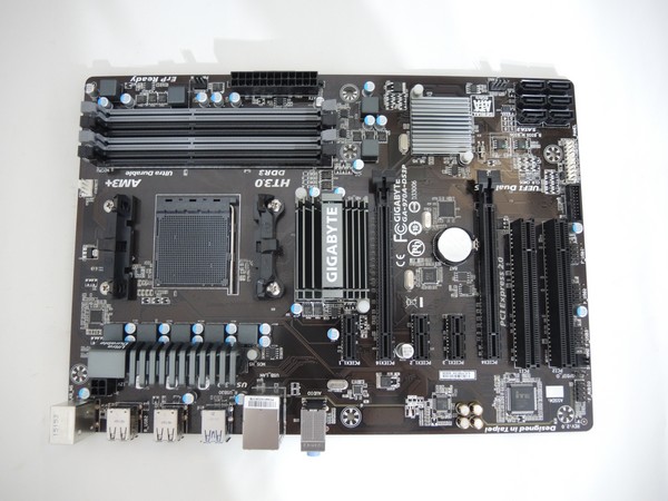 El mother tiene un PCB color negro con una capa protectora anti-humedad. En su frente deja ver sus disipadores para el puente norte y sur, cuatro ranuras de RAM y sus otros conectores como PCI-E y los 6 SATA.